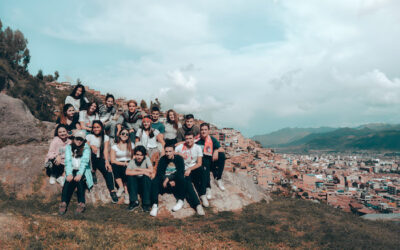 Group of students on hillside overlooking Cusco in mountainous landscape