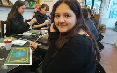 A young student smiling while painting in Buenos Aires