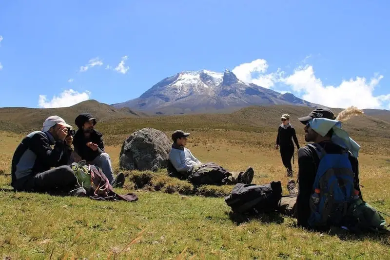 men sitting in front of colombia mountain