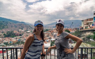 two students with medellin backdrop e1671631389458