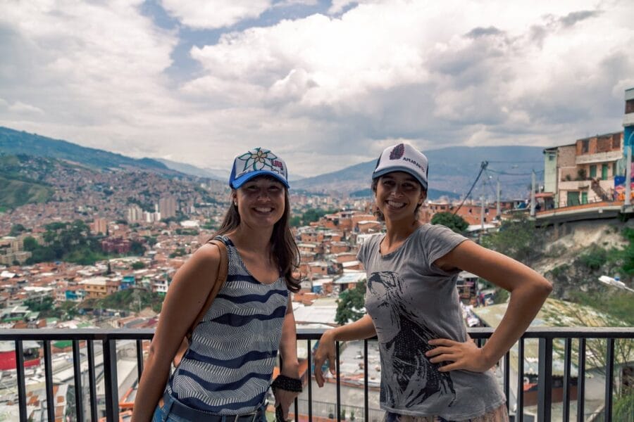 two students with medellin backdrop e1671631389458